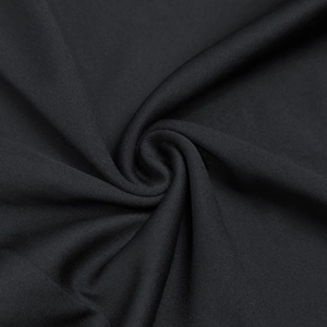 Detail view of black dress fabric showing intricate mesh texture and spiral drape folds