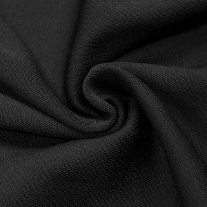 Gros plan détaillé montrant la texture du tricot noir haute densité et les strass brillants