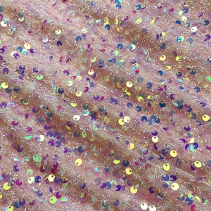 Detail shot of shimmering iridescent sequins on sheer mesh fabric for sequin dress