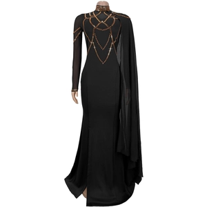 Détail de la robe noire avec paillettes dorées et cape asymétrique semi-transparente