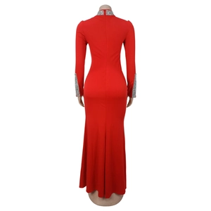 Détail de robe longue rouge avec sequins argentés aux poignets et fermeture éclair