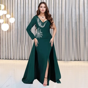 Detail of emerald green V-neck dress with silver sequin embroidery and high slit