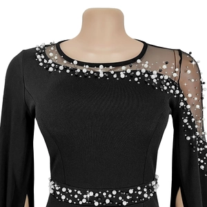 Detail of beaded pearls and mesh patchwork on the neckline of a black evening dress