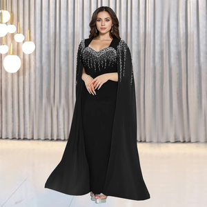 Détail d'une robe de soirée noire avec strass argentés et manches cape élégantes