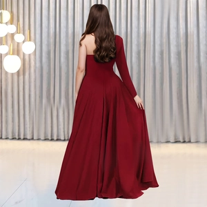 Rear view of an elegant burgundy one-shoulder evening gown with a flowing long skirt