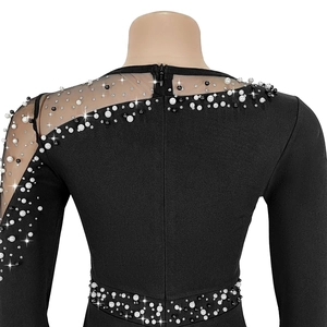 Detail of black evening dress featuring sheer mesh sleeves with pearls and beads