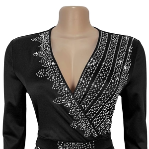 Detail of elegant black V-neck dress featuring sparkling silver rhinestone embellishments