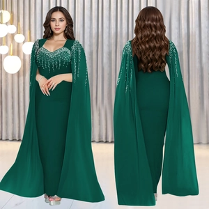 Détail de robe de soirée vert foncé avec col perlé et manches cape élégantes