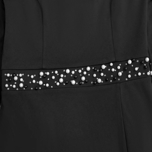 Detail of waist belt featuring white pearls, black beads and rhinestones on black dress