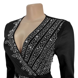 Close-up of deep V-neckline with intricate silver rhinestone geometric embellishments