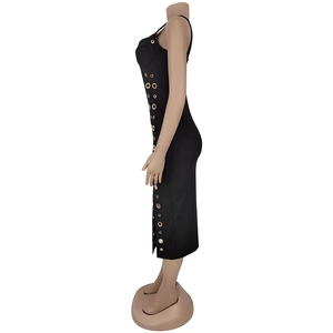 Détail d'une robe noire moulante avec des oeillets dorés verticaux sur le côté