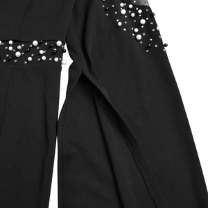 Detailed macro view of black evening gown featuring pearl beadwork and sheer mesh sleeves