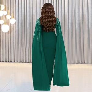 Détail de la robe de soirée vert foncé élégante avec manches cape à paillettes et coupe ajustée