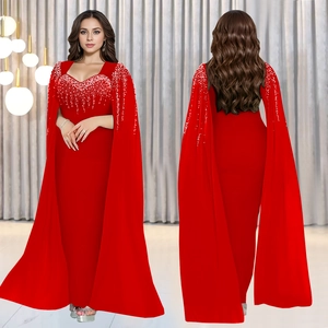 Détail de robe de soirée rouge élégante avec ornements en strass et manches cape