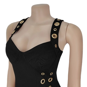 Détail de robe bandage noire élégante avec œillets dorés décoratifs et décolleté en cœur