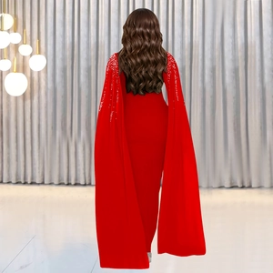 Détail d'une robe de soirée rouge avec manches cape et strass argentés étincelants