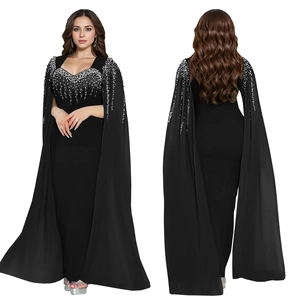Détail de robe de soirée noire avec manches cape à paillettes argentées et coupe ajustée