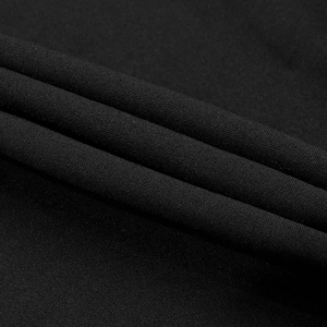 Close-up of black beaded evening dress fabric with grainy texture and soft drape