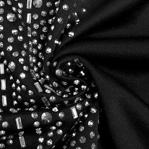 Macro detail of elegant black v-neck dress with sparkling rhinestones and baguette sequins