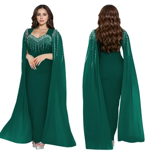 Détail d'une robe de soirée vert foncé avec manches cape et ornements en strass étincelants