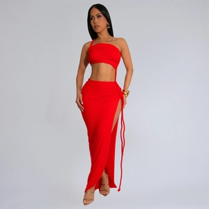 Détail de la robe en tricot rouge montrant la fente latérale avec tissage de corde