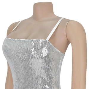 Detail of silver sequined party dress featuring thin straps and sparkling embroidery