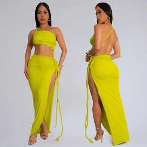 Détail d'un ensemble deux pièces vert citron avec haut asymétrique et jupe longue fendue