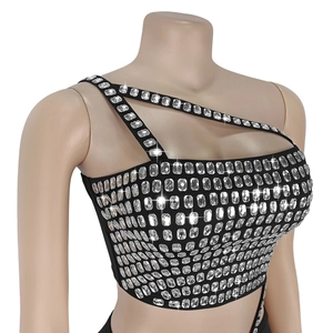 Détail du haut court noir moulant avec ornements en strass argentés et découpe