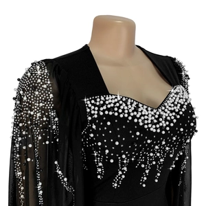 Détail d'une robe noire élégante avec perles brodées et manches en tulle transparent