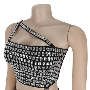Détail d'un top noir asymétrique court avec strass scintillants pour tenue de soirée chic