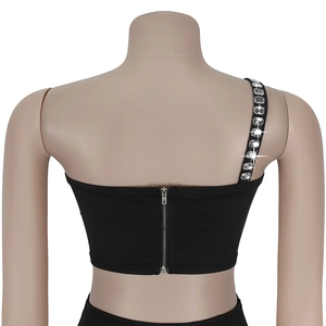 Détail d'un crop top noir avec bretelle en strass et fermeture éclair argentée au dos
