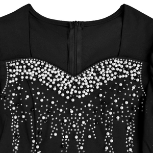 Détail d'une robe noire montrant des perles et des strass sur l'encolure avec fermeture éclair