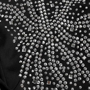 Detailed macro shot of sparkling rhinestones on elegant black V-neck dress fabric