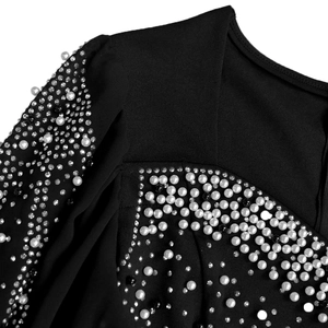 Détail macro d'une robe noire élégante avec broderies de perles et strass argentés brillants