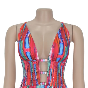 Detail des tiefen V-Ausschnitts mit bunten Perlen und gesmokter Taille mit Blumendruck