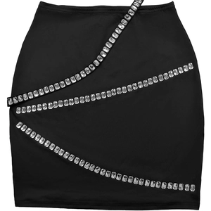 Détail d'une mini-jupe noire ornée de trois rangées diagonales de strass étincelants