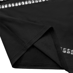 Détail du tissu élastique noir avec bordure en strass et couture surjetée