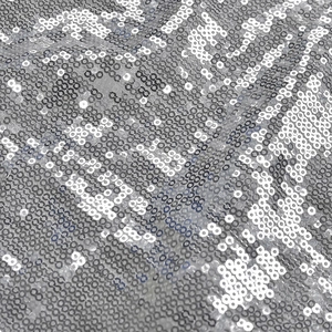 Macro shot of shimmering silver circular sequins on evening gown fabric with metallic luster