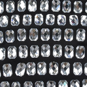 Détail macro de strass rectangulaires scintillants sur le tissu en maille noire
