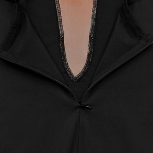 Détail d'une fermeture éclair invisible et empiècement en mesh sur robe noire