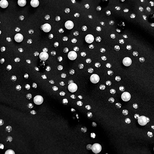 Vue détaillée des strass et perles élégants sur le tissu noir de la robe de soirée