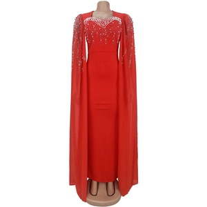 Détail d'une robe de soirée rouge avec perles et strass sur l'encolure et manches cape