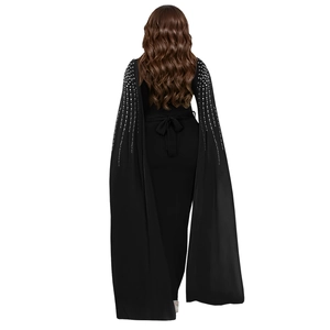 Detail of rhinestone cape sleeves and back bow on a black elegant evening dress