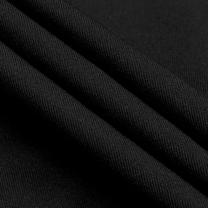 Gros plan détaillé du tissu en maille côtelée noire montrant la texture et la densité