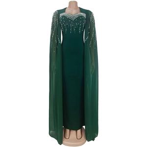 Détail d'une robe de soirée vert foncé avec perles et manches cape en voile léger
