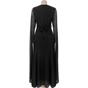 Detail of back view black dress featuring rhinestone shoulder decor and waist tie bow