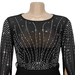 Close-up of sparkling silver rhinestones on elegant black mesh long sleeve dress