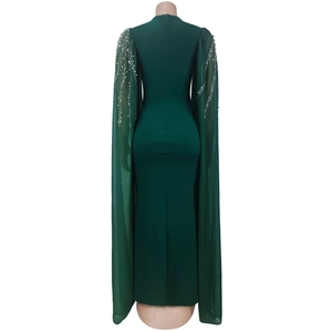 Détails de la robe vert foncé avec manches cape ornées de strass et texture raffinée