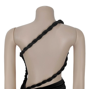 Détail d'une robe noire dos nu montrant une bretelle en corde tissée en spirale épaisse