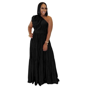 Détail d'une robe longue noire asymétrique à volants étagés avec texture plissée et taille ajustée